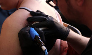 A survivor of the Manchester Arena attack getting a bee tattoo on the anniversary in May 2018.